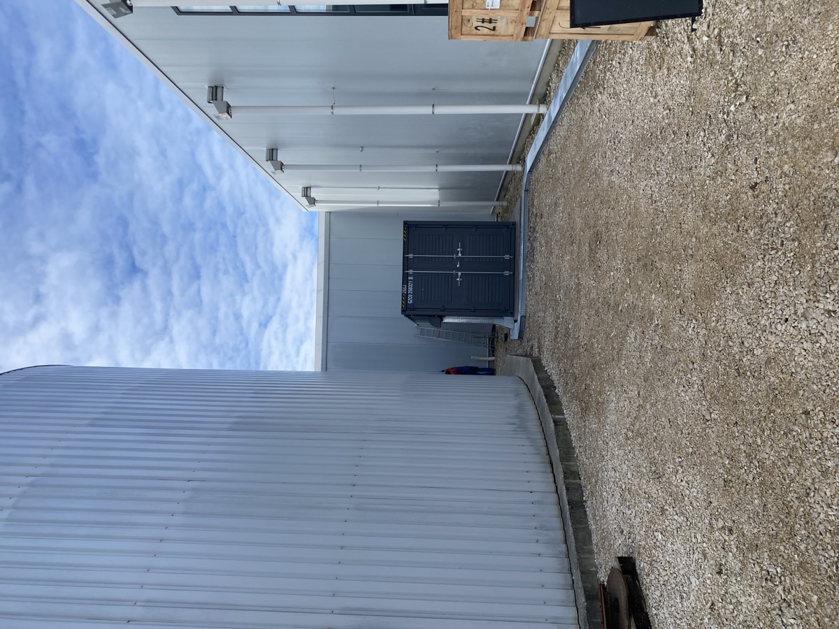 Intégration sur site K51 — conteneur serveur entre réservoir tampon thermique et serre / K51-Standortintegration — Servercontainer zwischen Pufferspeicher und Gewächshaus